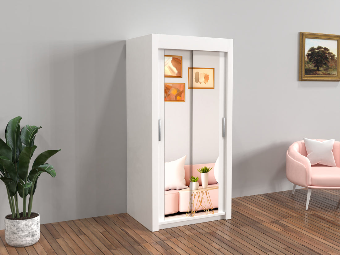 White wardrobe with sliding doors in a room with a pink chair and plant.