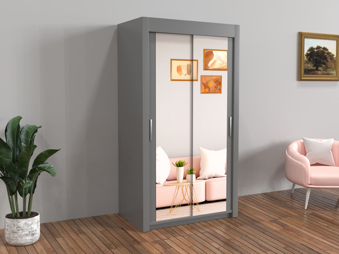 Gray wardrobe with sliding doors in a room with a pink sofa and plant.