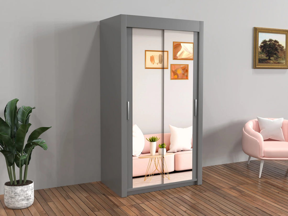 Gray wardrobe with sliding doors in a room with a pink sofa and plant.