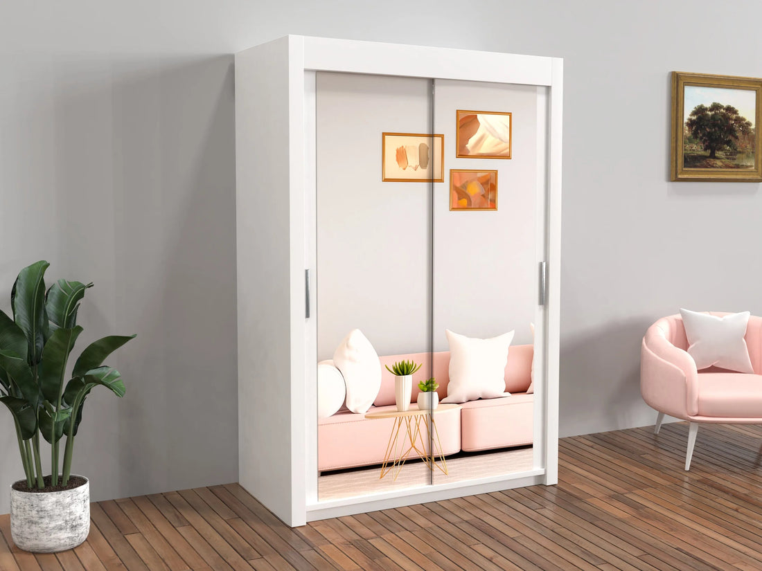 White wardrobe with sliding doors in a room with pink sofa and chair.