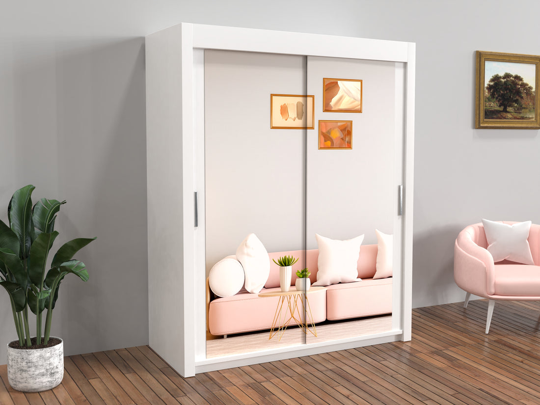 White wardrobe with sliding doors in a room with pink sofa and chair.