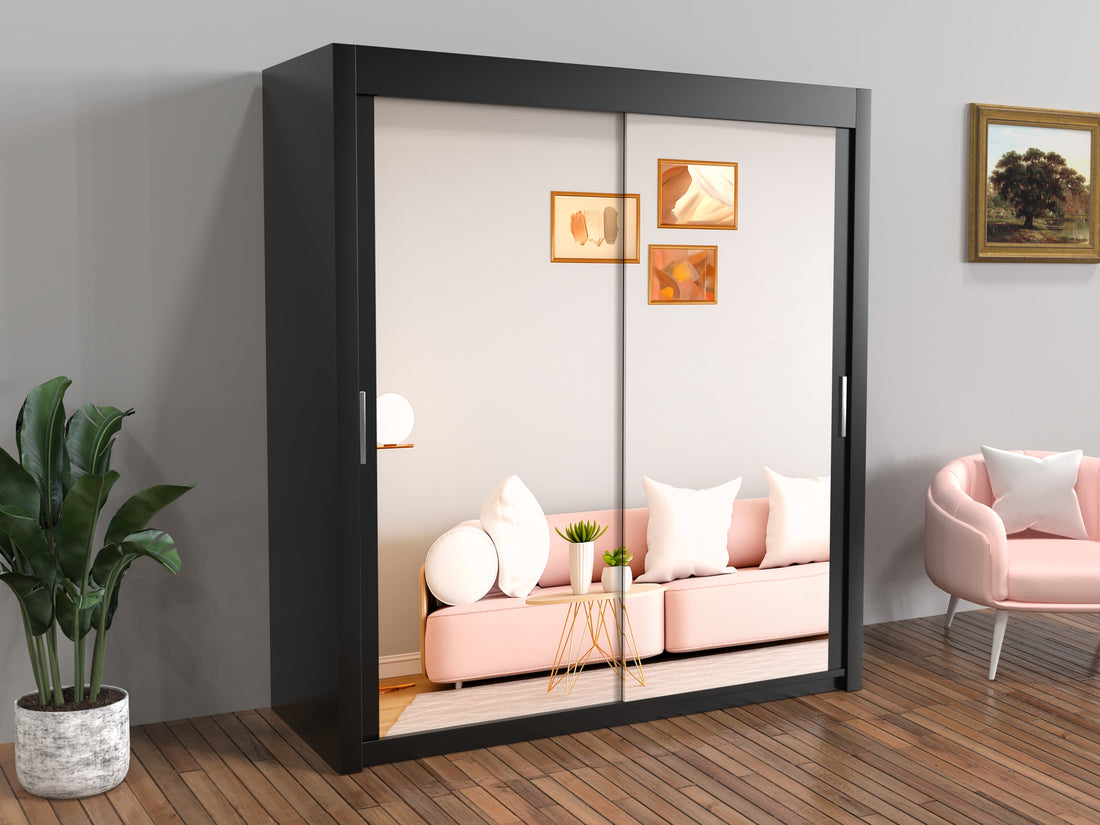Black sliding wardrobe with a reflection of a living room with pink sofa and decor.